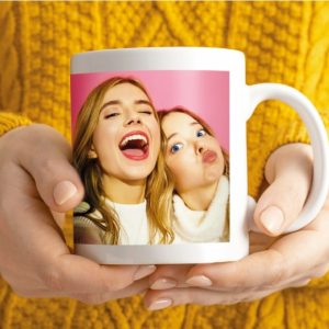 a person holding a mug with a picture of two women